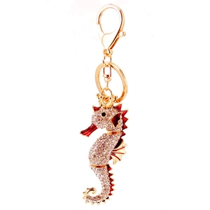 Golden seahorse keychain with sparkling crystals and red enamel detailing for handbags