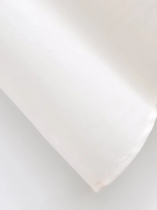 Detailed macro view of white fabric texture and fine stitching on a bow-knot dress