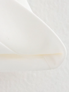 Vue macro détaillée montrant le tissu en sergé blanc de qualité et les coutures du haut