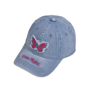 Detail of light blue denim baseball cap with butterfly patch and Free Flight embroidery