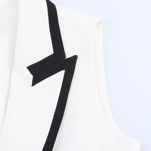 Detailed macro view showing the black contrast trim and fabric texture of the white vest