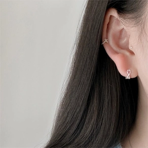 Close-up of S925 sterling silver cross ear cuff and knot stud earrings with zircon