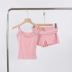 Close-up of pink modal pajama set featuring lace trim and rhinestone G detail