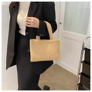 Chic beige teddy faux fur tote bag held by a model wearing a professional black blazer