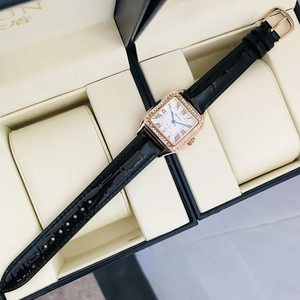 Detail of luxury square rose gold watch with diamond bezel and black leather strap