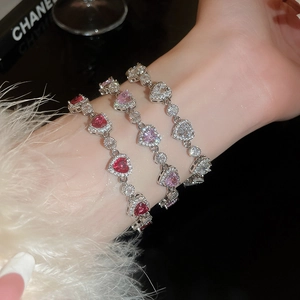 Detailed view of heart-shaped zircon tennis bracelets in ruby red, pink, and white crystal