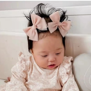 Pink mesh bow hair clips for baby girls worn by a cute model in a soft lighting setting