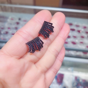 Macro shot of industrial black zircon ear studs with multi-row pavé setting on hand