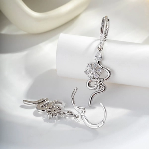 Silver snake-shaped hoop earrings with snowflake charms and teardrop cubic zirconia accents