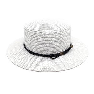 Detail of white straw boater hat featuring black braided rope and bronze metal accents