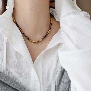 Vintage beaded choker with faux tiger eye stones and gold metal accents on a model