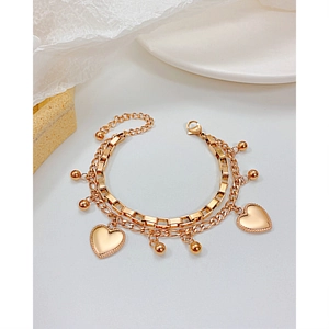 Detail of layered stainless steel heart bracelet featuring beads and a lobster clasp