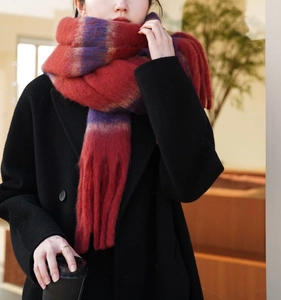 Detailed view of plush red and purple gradient scarf with stylish braided tassels