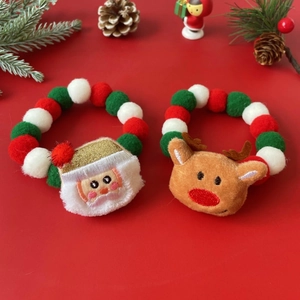 Christmas pet collar with colorful pom poms, Santa and reindeer charms on red background