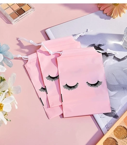 Pink frosted drawstring bags with eyelash print shown with makeup accessories