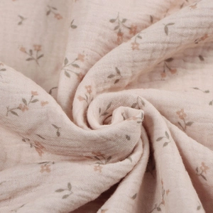 Detailed close-up of soft floral cotton muslin fabric with breathable crinkle texture