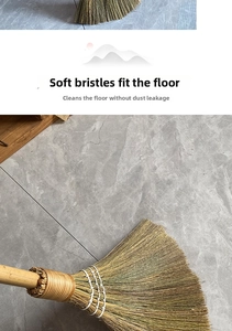 Detail of fan-shaped natural fiber broom head touching grey marble tile floor surface