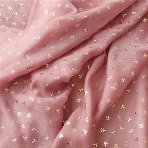 Close-up of pink bali yarn fabric featuring delicate gold foil bean sprout patterns