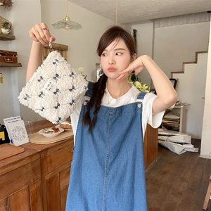 Close-up of fluffy white lamb wool cosmetic bag with black bow patterns and label