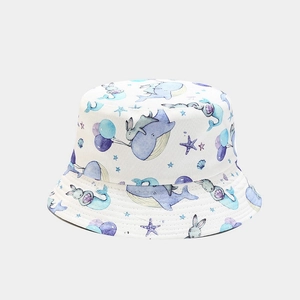 Close-up of cute cartoon whale and bunny prints on a white cotton bucket hat for kids