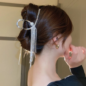 Détail de la pince à cheveux argentée avec longues franges en strass et perle centrale