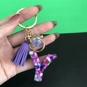 Detailed macro view of resin alphabet Y keychain with purple tassel and gold hardware