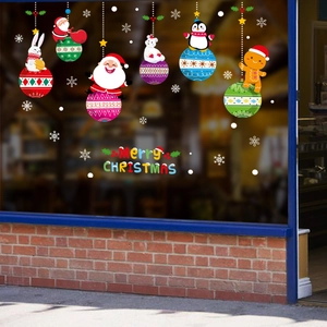 Détail de stickers de Noël colorés avec Père Noël et pingouin sur vitrine de magasin