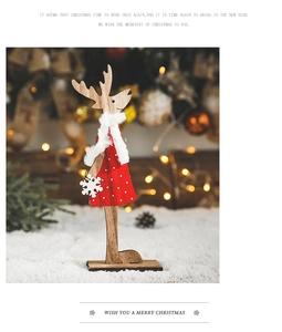 Détail de renne de Noël en bois avec robe à pois rouges et écharpe en peluche blanche