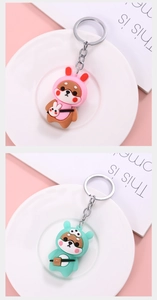 Detail of Shiba Inu keychains in pink bunny and mint green styles with silver links