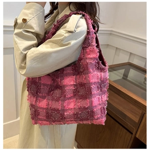 Detailed shot of a pink and purple plaid tote bag with brushed fringe texture and soft design