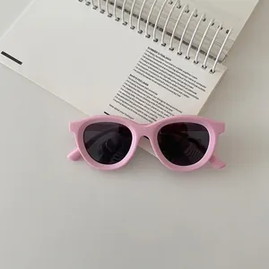 Top view of pink silicone children's polarized sunglasses on a white spiral notebook