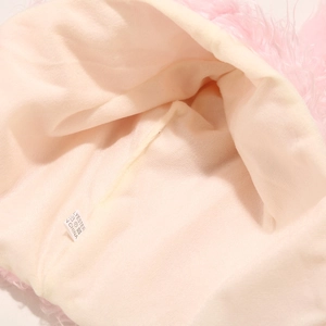 Détail de la doublure rose du bonnet en peluche avec étiquette de lavage en polyester