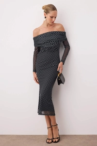 Detailed view of mesh fabric texture and white polka dots on an off-shoulder dress