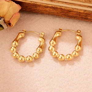 Vue détaillée de boucles d'oreilles en U en acier doré avec texture perlée élégante