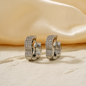Sparkling silver hoop earrings with cubic zirconia pave on elegant champagne silk background