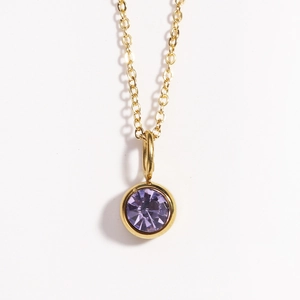 Gold birthstone necklace with a round purple gemstone pendant on a classic cable chain