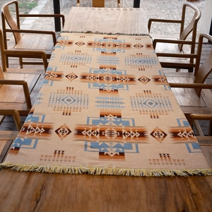 Bohemian geometric picnic blanket and woven sofa throw with fringes in warm earthy tones