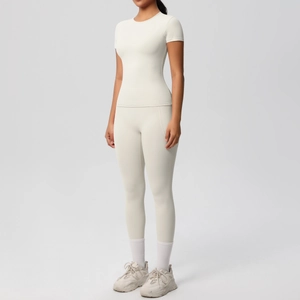 Detail of cream white yoga set featuring high-waist leggings with side pockets and slim T-shirt