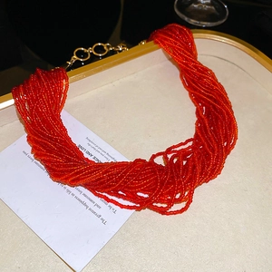 Dettaglio di una collana di perline multicolore a più strati su un vassoio bianco