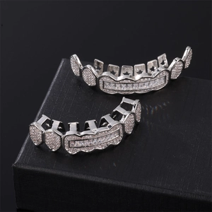 Iced out silver grillz set with sparkling diamonds on a black textured jewelry box