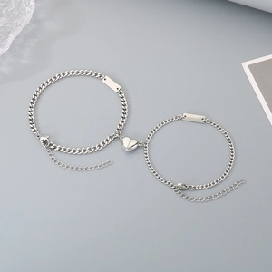 Detail of stainless steel heart magnet buckle and square tags on couple bracelets