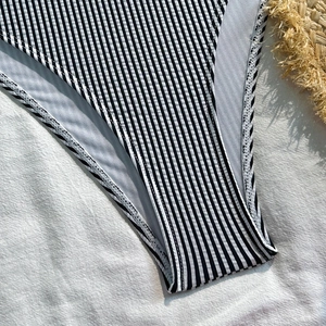 Close-up of vertical striped seersucker swimsuit fabric with detailed stitching and lining