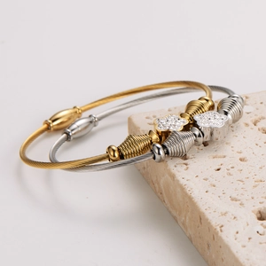 Floral stainless steel cable bracelet with pavé crystal accents in gold and silver finish