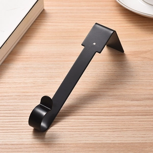 Close-up of a sturdy black metal Christmas stocking hook on a light wood surface