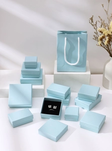 Collection of light blue jewelry gift boxes and bags featuring a minimalist matte finish