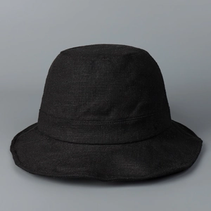 Close-up of the breathable black linen fabric texture on a minimalist bucket sun hat