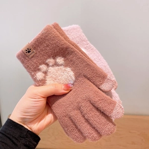 Close-up of winter knit gloves featuring a cute brown and pink plush cat paw design