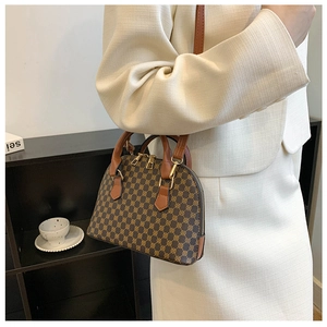 Brown geometric shell bag worn by model in cream suit for casual elegant look