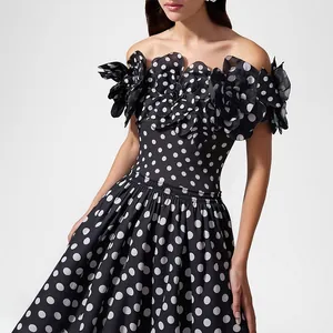 Close-up of retro polka dot dress featuring 3D floral ruffles and off-shoulder design