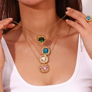 Close-up of vintage 18K gold plated square zircon necklaces and ring on a model